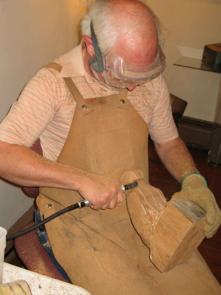gary carver using power carving tools to carve a wooden bird