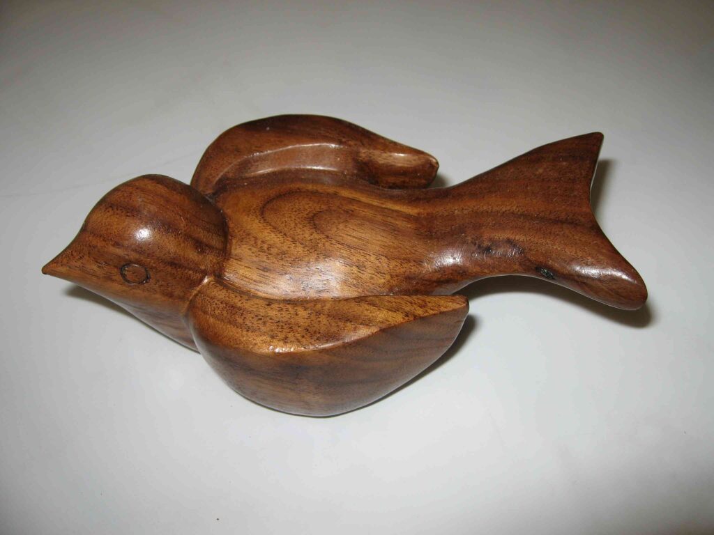 stylized wood carving of a winged little backyard bird by gary carver of carverscarvings