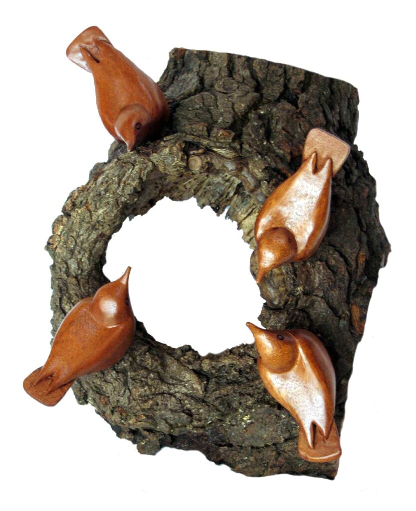 four stylized wood carvings of nuthatch birds mounted on a burl of wood by gary carver of carverscarvings