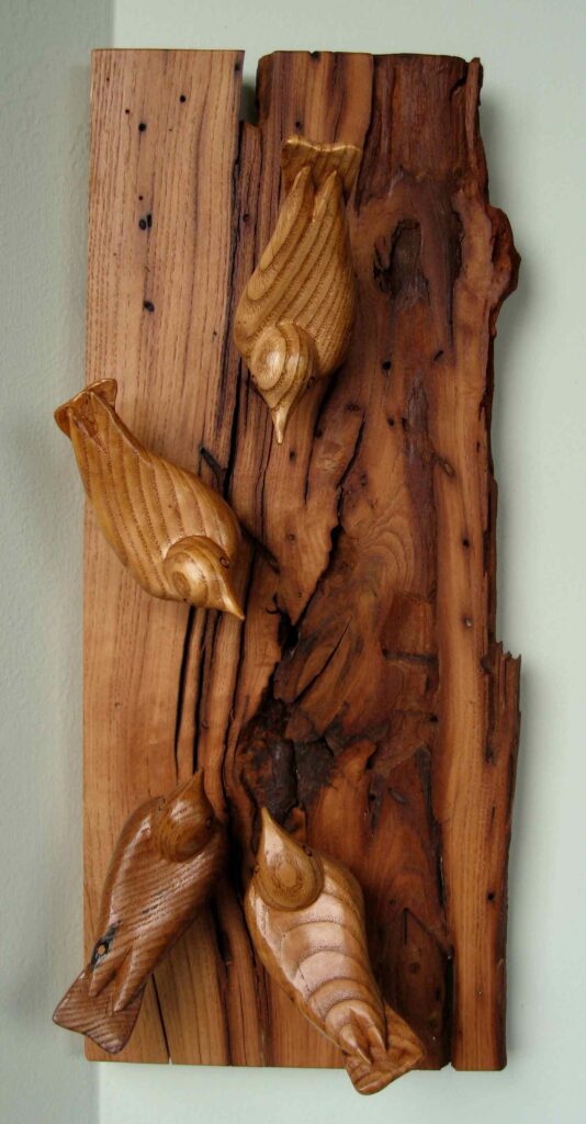 four stylized nuthatches wood carvings on a slab of american chestnut by gary carver of carverscarvings