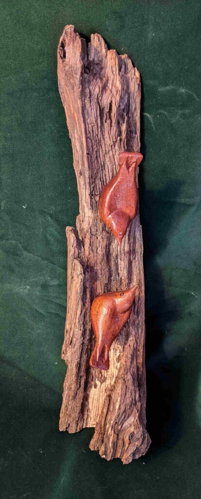 two stylized wood carvings of nuthatch birds mounted on a pinnacle structure of wood by gary carver of carverscarvings