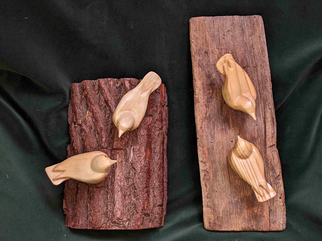 two separate wood carvings of nuthatches on wall hangings by gary carver of carverscarvings