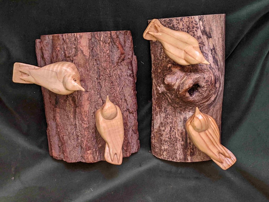 two separate stylized wood carvings of two nuthatches wall hangings by gary carver of carverscarvings