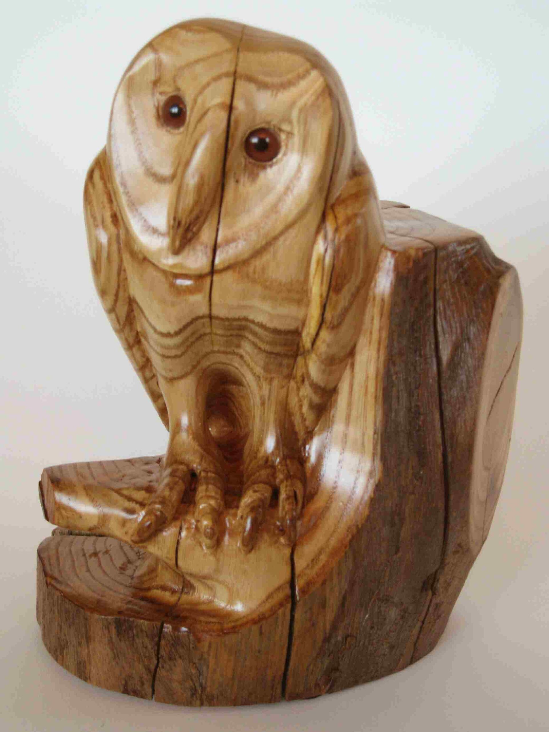 stylized chestnut wood carving of a baby barn owl by gary carver of carverscarvings