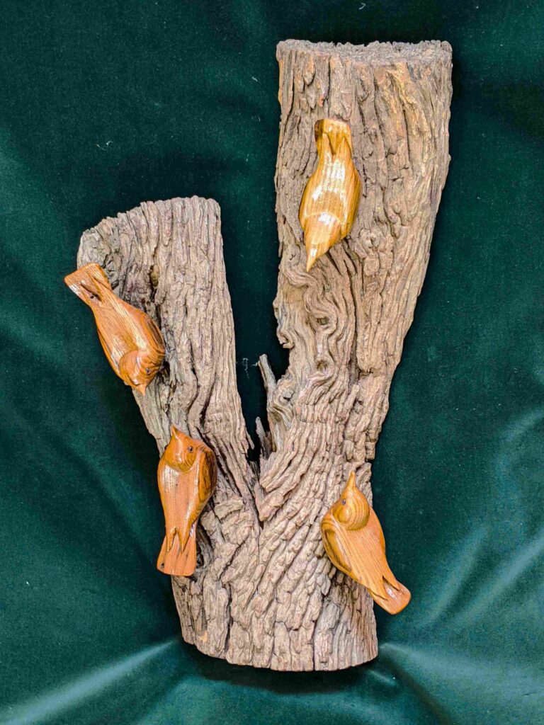 four stylized wood carvings of nuthatches by gary carver of carverscarvings